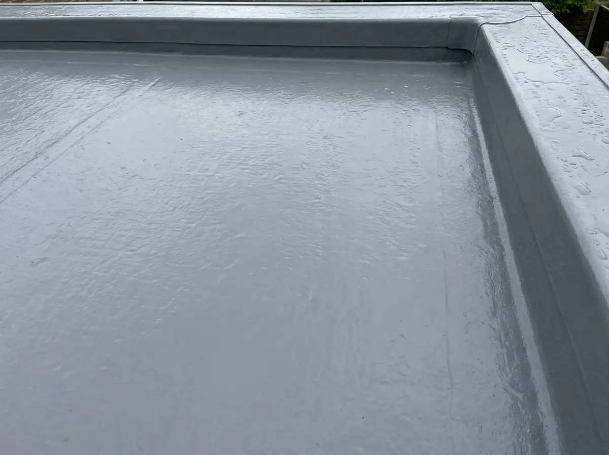 Smooth hard grey GRP fibreglass flat roof installation with preformed edge trims